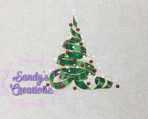 A tea towel embroidered with an exquisitely detailed Christmas details of gold ribbons circling the tree